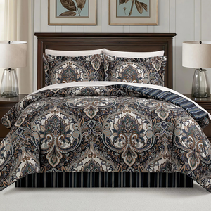 A bed set featuring a detailed paisley pattern with matching pillow shams, set against a dark wooden bed frame. Two table lamps with clear glass bases are on the nightstands beside the bed.