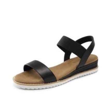 A black sandal with two straps over the foot and a beige cushioned sole. The sandal features a low platform with a ridged white outsole.
