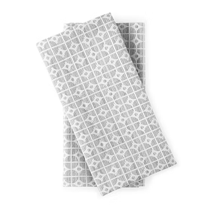 Two folded textiles featuring a gray repeating pattern of circles and squares on a white background.