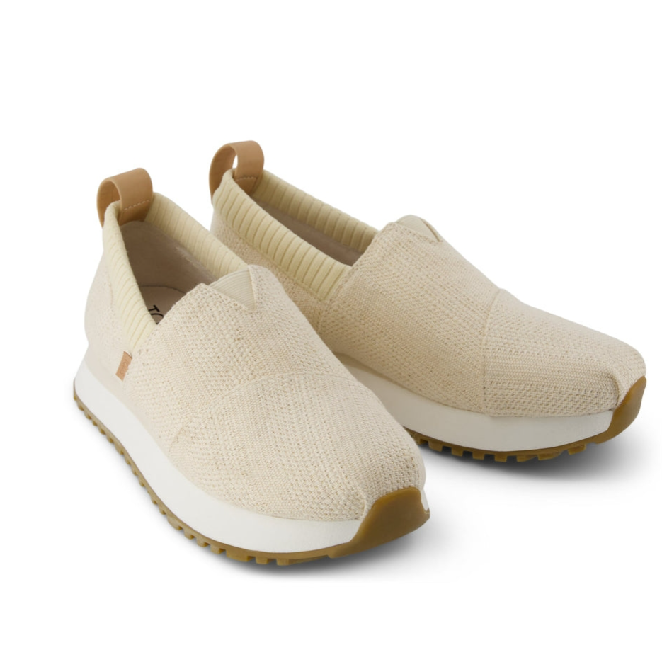 Beige slip-on sneakers with a knitted texture, rubber sole, and pull tabs at the heel.