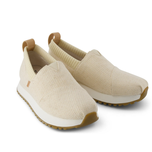 Beige slip-on sneakers with a knitted texture, rubber sole, and pull tabs at the heel.
