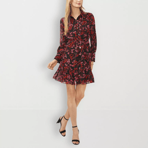 A woman is wearing a black floral print dress with long sleeves and a belted waist, accompanied by black ankle-strap high heels.