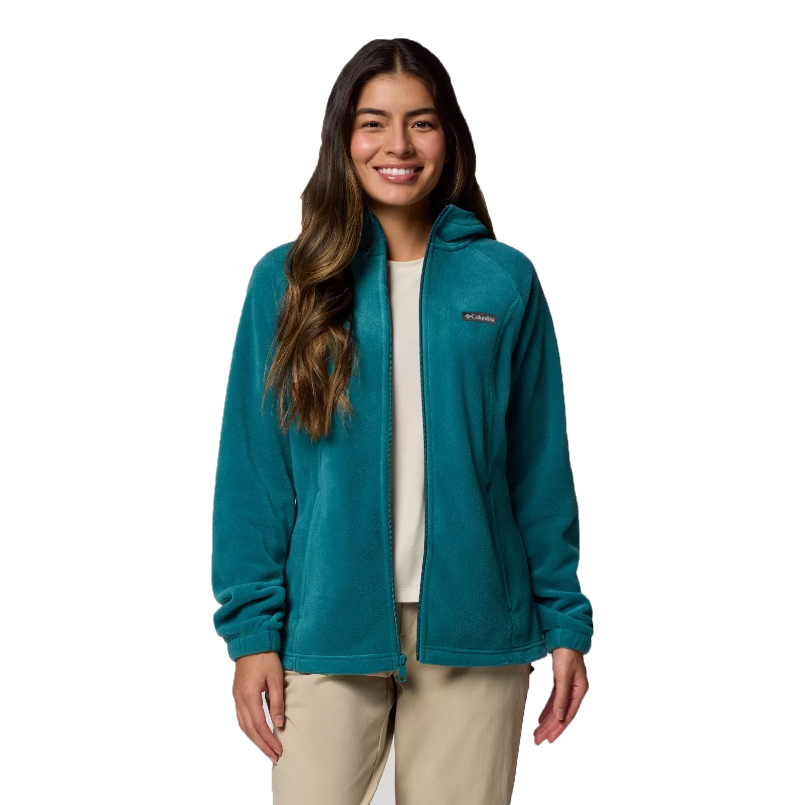 A woman is wearing a teal Columbia fleece jacket with a full zip and elastic cuffs, paired with beige pants.