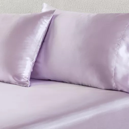 Light purple satin pillowcases and bed sheet.