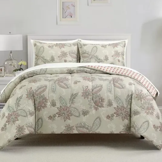 A white bed with a floral-patterned comforter set, including two matching pillow shams, is flanked by two white nightstands with lamps and decorative items. The wall features two framed prints and small windows, creating a cozy, coordinated bedroom look.