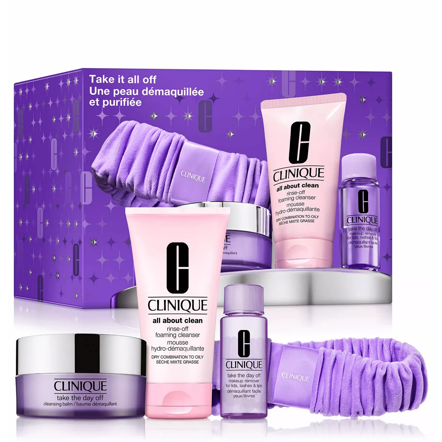 Clinique's \“Take it all off\“ skincare set includes a cleansing balm, rinse-off foaming cleanser, makeup remover for lids, lashes, and lips, and a purple headband in a purple-themed box.
