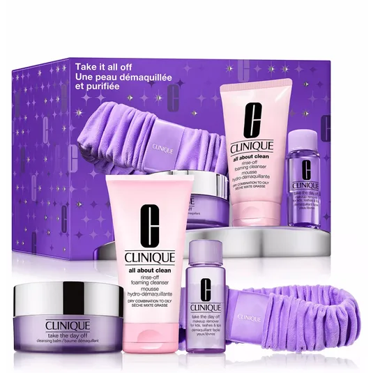 Clinique's \“Take it all off\“ skincare set includes a cleansing balm, rinse-off foaming cleanser, makeup remover for lids, lashes, and lips, and a purple headband in a purple-themed box.