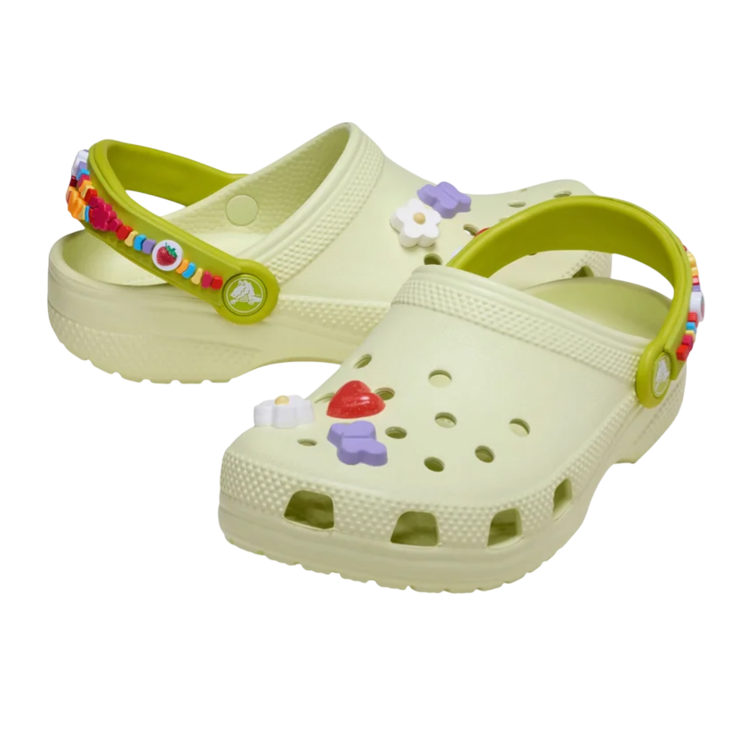 Light green Crocs adorned with colorful charms, including flowers and hearts, featuring a beaded strap detail.