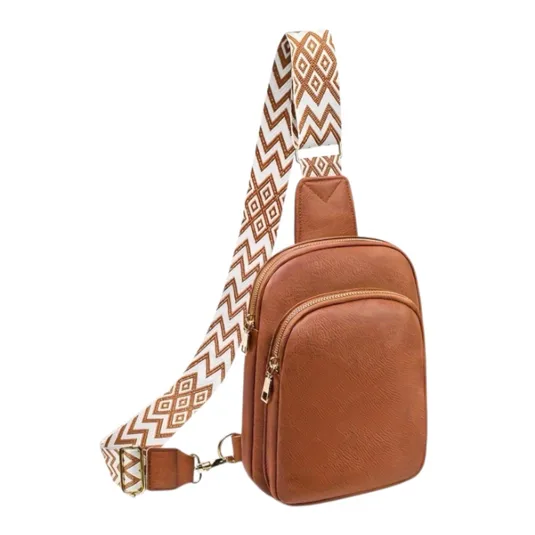 Brown sling bag with two zippered compartments features an adjustable strap with a white and brown geometric pattern.