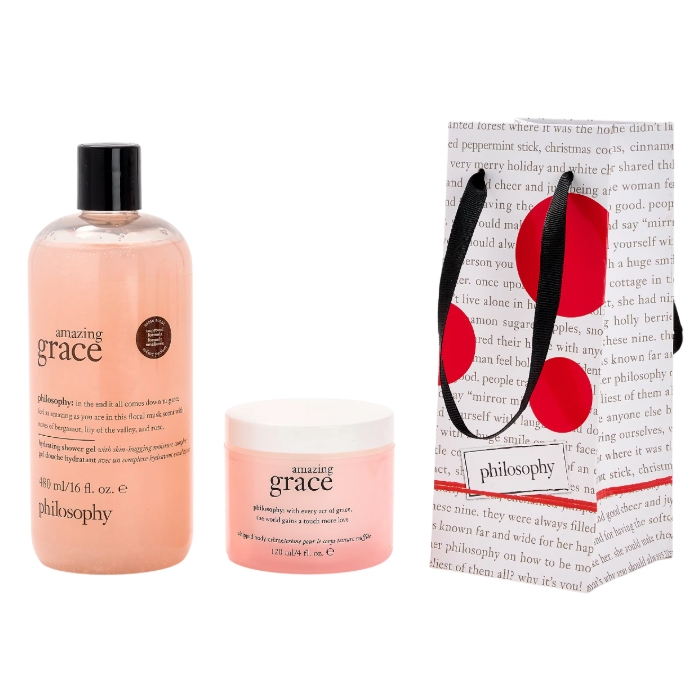 Philosophy Amazing Grace Set includes a 16 fl. oz. shower gel and a 4 oz. whipped body crème, both in pink containers, accompanied by a decorative gift bag featuring text and red dot designs.