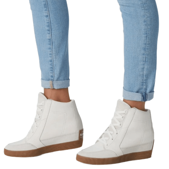 White high-top sneakers with gum soles paired with light blue cuffed skinny jeans.