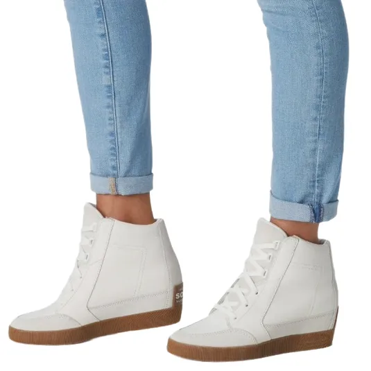 White high-top sneakers with gum soles paired with light blue cuffed skinny jeans.