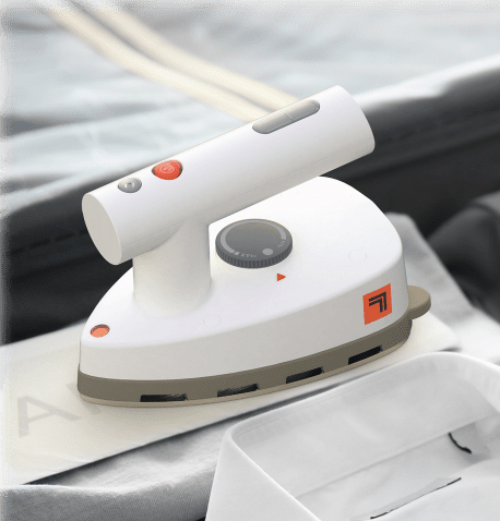 A handheld garment steamer with a white and beige design and red accent buttons.