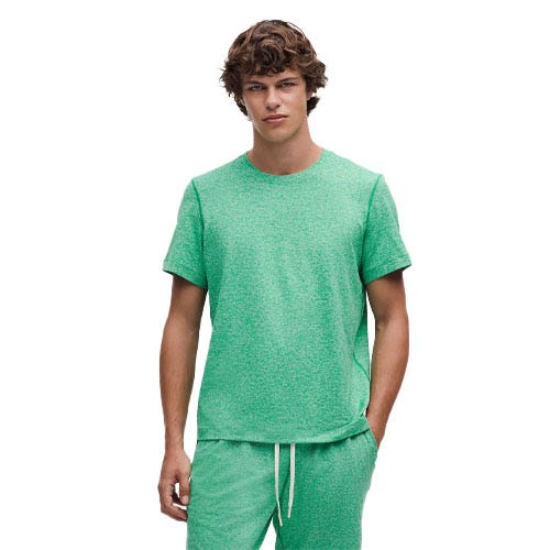 A person is wearing a green short-sleeve T-shirt paired with matching green drawstring shorts.