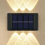 Wall-mounted solar-powered light with dual illumination to provide lighting above and below.
