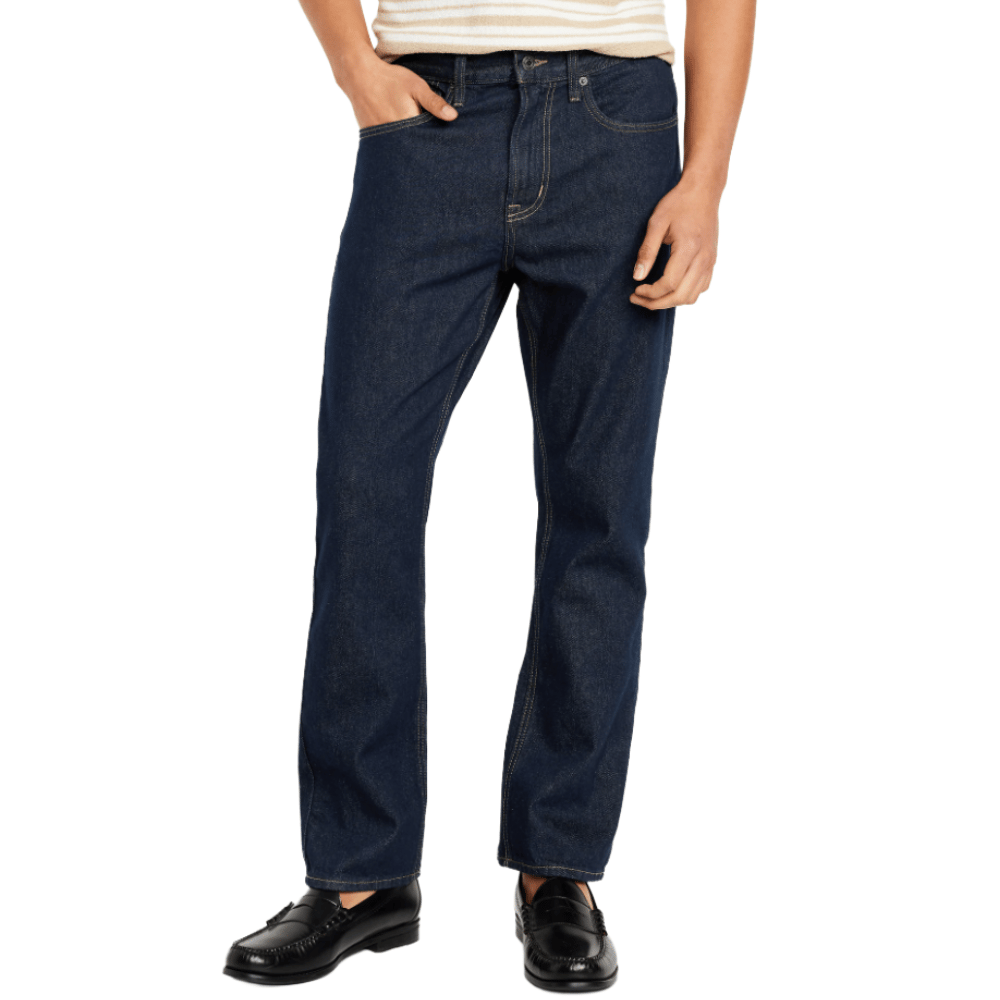 A person is wearing dark blue jeans paired with black loafers and a striped shirt.