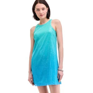 A woman wears a sleeveless, blue-green ombre dress with a shimmering texture. The dress has a straight, knee-length design with a high neckline.