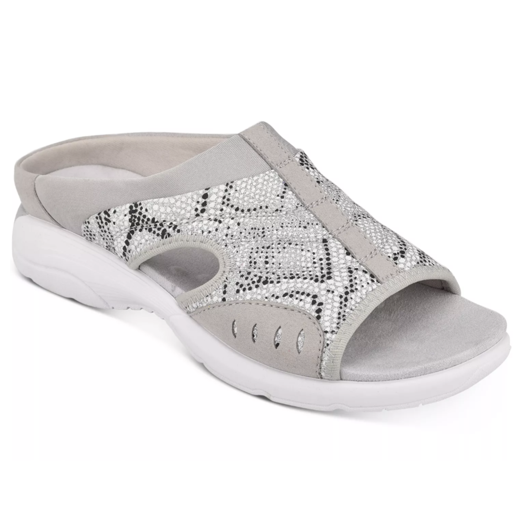 A light gray slip-on sandal with a white sole and open toe design, featuring a snakeskin pattern with metallic accents for casual wear.