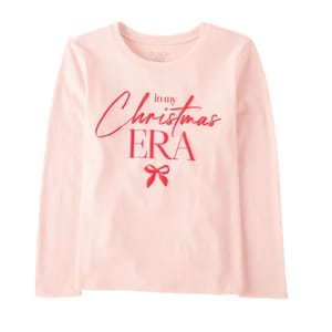 A long-sleeve pink shirt with red text that says \“in my Christmas ERA\“ along with a small red bow graphic below the text.