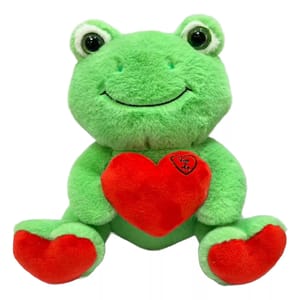 A plush green frog with a smile is holding a red heart. The heart has \“You & Me\“ written on it.