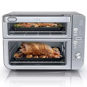 Ninja DoubleStack XL Oven is a countertop appliance with two cooking compartments, allowing for simultaneous baking and roasting. It features digital controls and a stainless steel finish, shown roasting a chicken and vegetables on the bottom and baking on the top.