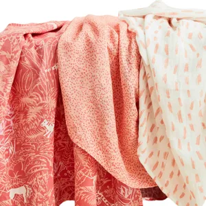 Three textiles in coral and white shades feature different patterns: a jungle scene, small dots, and abstract brush strokes.