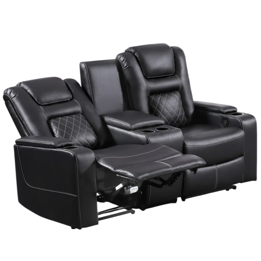 Black leather reclining loveseat with cup holders and a center console, set in a living room with a patterned rug and wooden flooring.