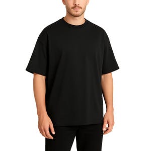 A man is wearing a plain black oversized short-sleeve crew neck t-shirt with matching black pants.