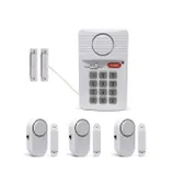 A home security system with a keypad, door sensors, and alarm units. The components include a keypad with a panic button and switch settings, and several wireless magnetic door/window alarm sensors.