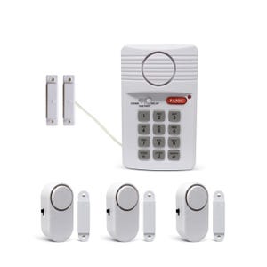 A home security system with a keypad, door sensors, and alarm units. The components include a keypad with a panic button and switch settings, and several wireless magnetic door/window alarm sensors.