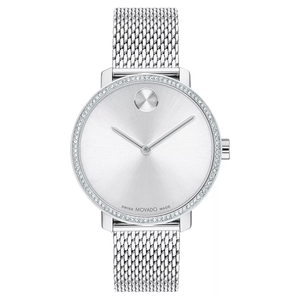 Silver watch with a minimalist design featuring a round case, diamond-accented bezel, two hands, and no numerals, paired with a mesh bracelet.