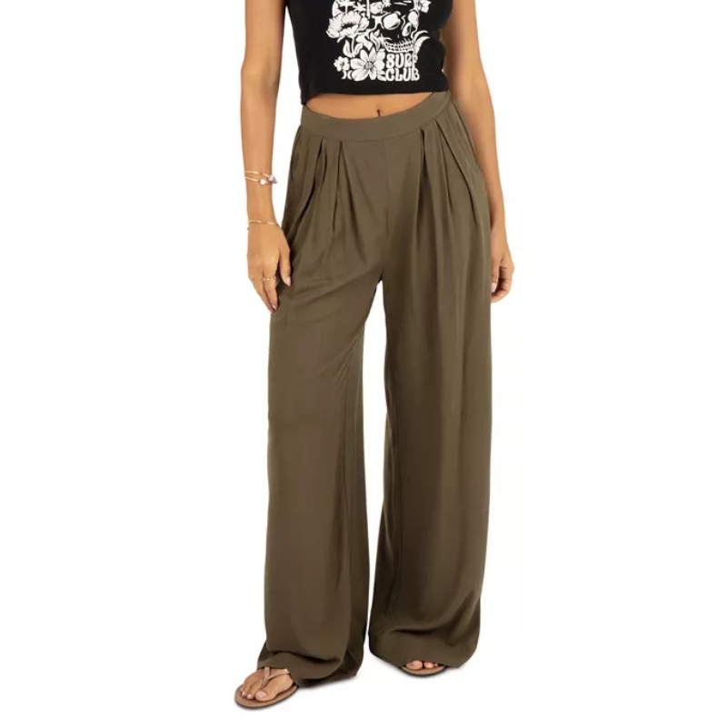 Hurley Juniors' Beach Pants are olive green with a wide-leg design, featuring pleats at the waist for a relaxed fit, paired here with a black crop top and sandals.