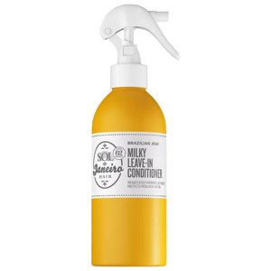 A yellow-tinted transparent spray bottle with white labeling displaying \“Sol de Janeiro Brazilian Joia Milky Leave-In Conditioner\“ text, featuring a white spray nozzle.