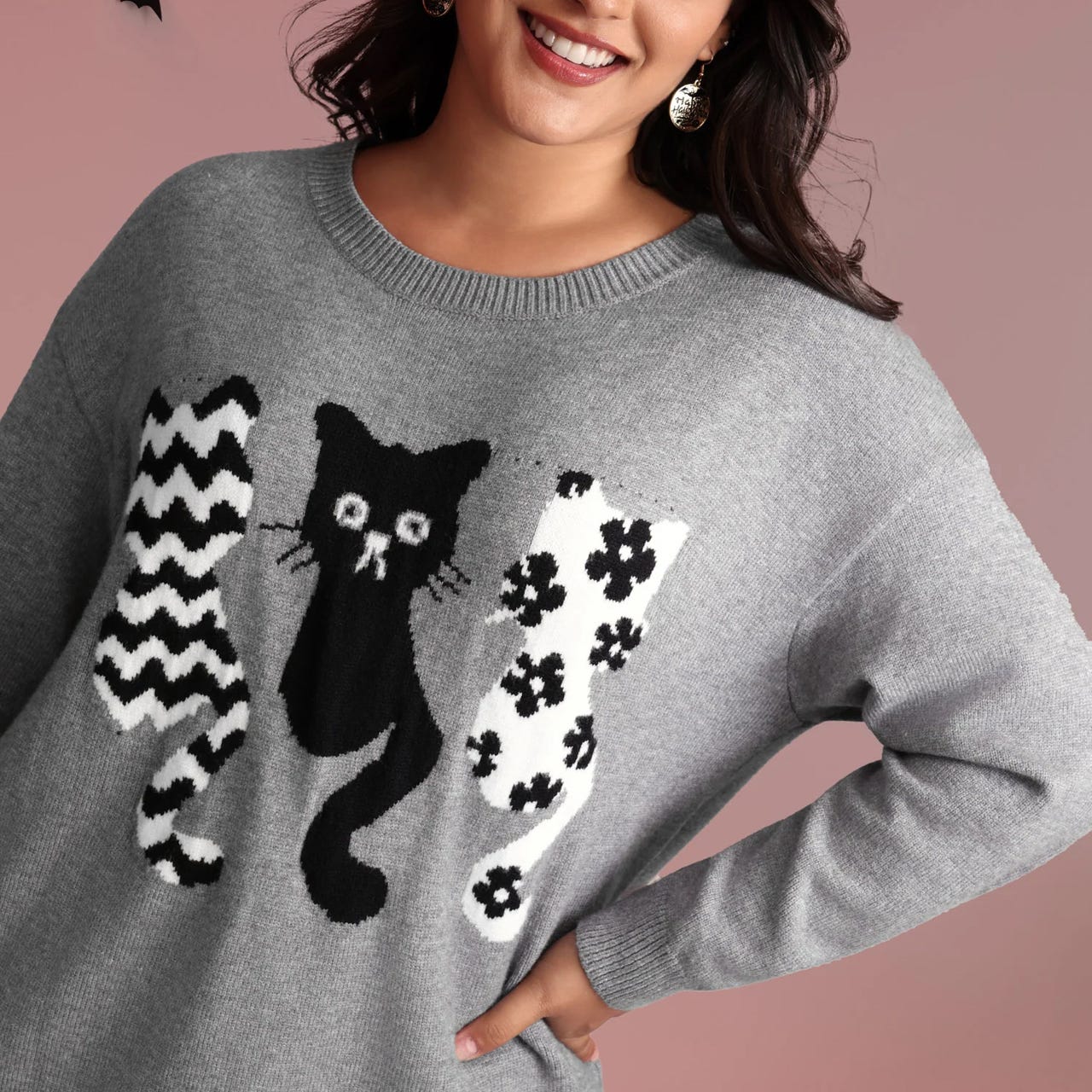 A gray sweater featuring three stylized black and white cat designs with geometric and floral patterns.