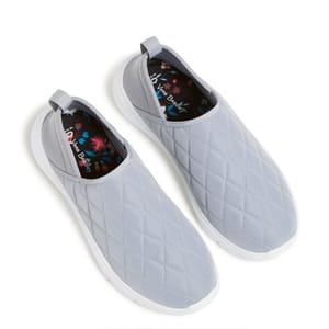 A pair of light gray, quilted slip-on sneakers with floral insoles.