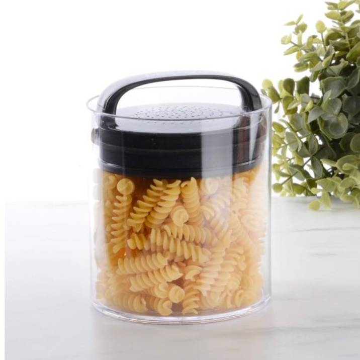 A transparent airtight food container with a black handle and lid, filled with uncooked fusilli pasta.