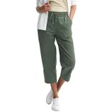 A person wears cropped green drawstring pants paired with a white shirt and sneakers.
