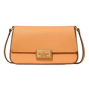 An orange Kate Spade New York shoulder bag with a rectangular gold logo plate on the front flap.