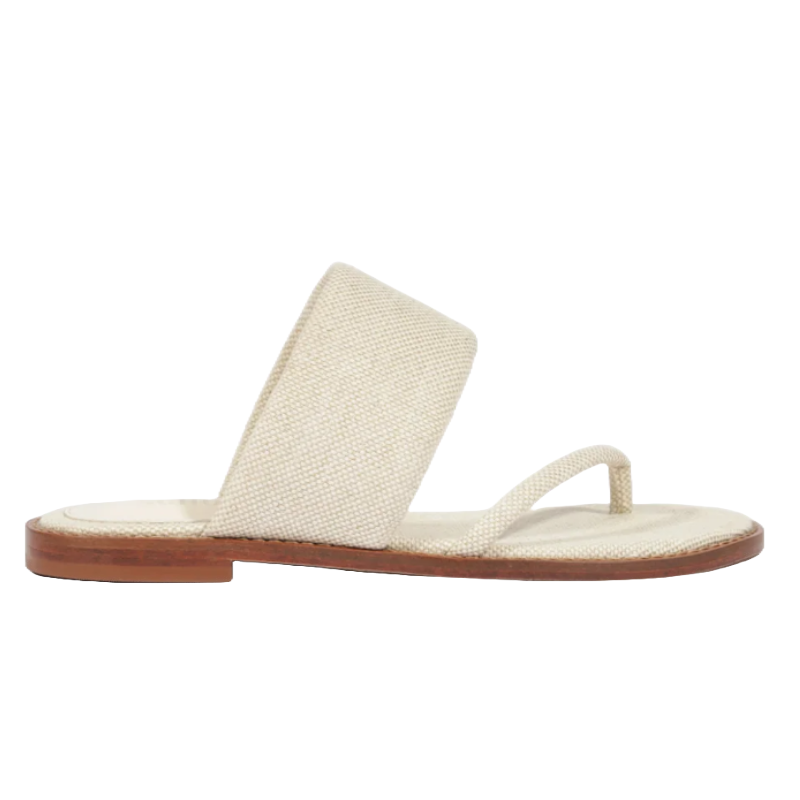 A beige sandal featuring a wide strap and a thong-style toe loop, with a flat brown sole.