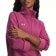 A person is wearing a pink Under Armour half-zip pullover with rolled-up sleeves, featuring the brand's logo on the chest.