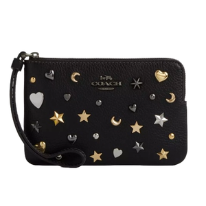 Black Coach wristlet with metallic embellishments of hearts, stars, and moons, featuring a zip closure and a detachable wrist strap.
