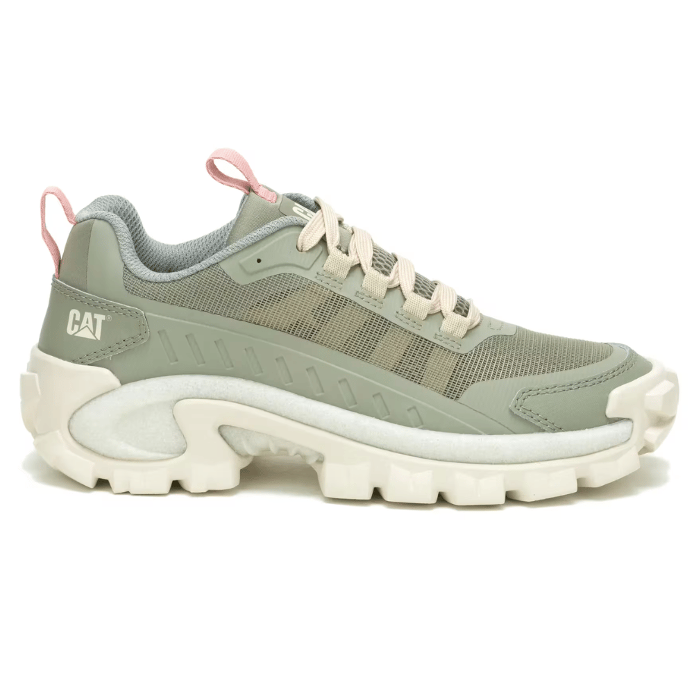 A light green sneaker with a rugged sole, branded with \“CAT,\“ features pink accents and beige laces, designed for casual wear.