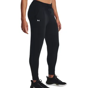 Black Under Armour joggers with an elastic waistband, side pockets, and a logo on the left thigh, paired with black athletic shoes.