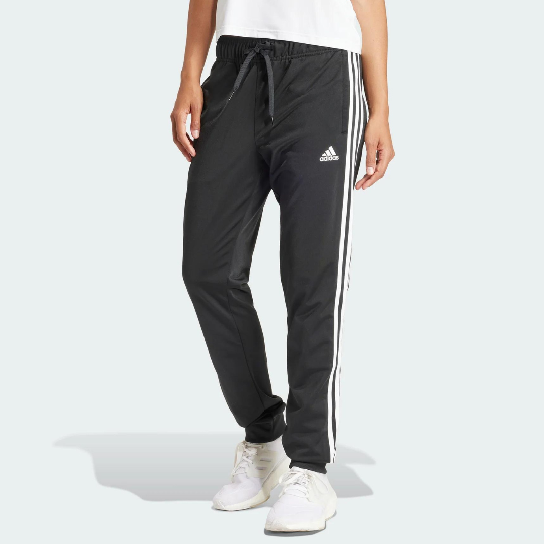Black athletic pants with white stripes along the legs, paired with white sneakers.
