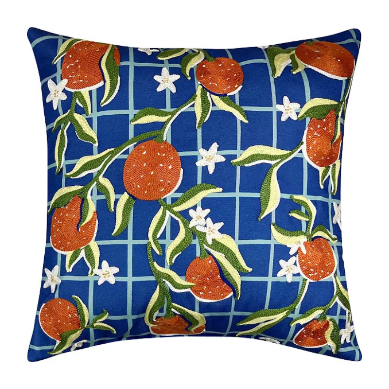 Square pillow with a blue grid background featuring orange fruits, green leaves, and white flowers.