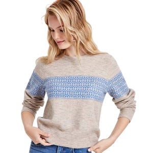 The Levi's Fair Isle Stripe Sweater is a beige crewneck with a blue Fair Isle pattern across the chest and sleeves. It features long sleeves with ribbed cuffs and hem, paired with a casual fit.