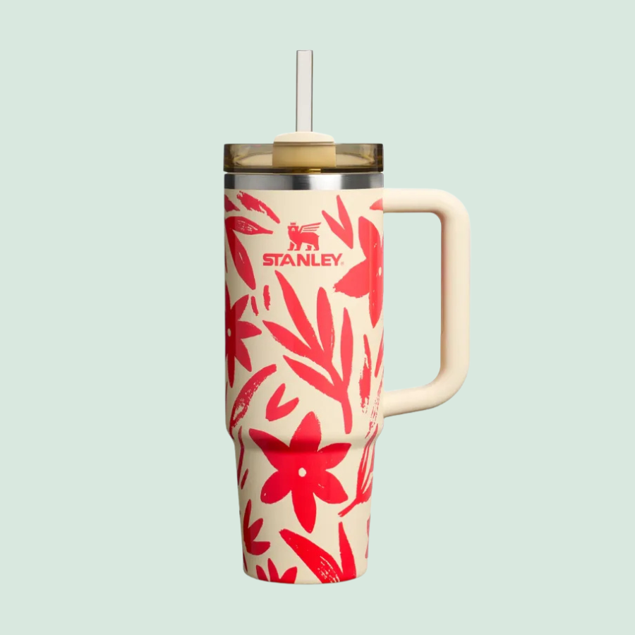 Stanley tumbler with red floral design, featuring a handle and straw.