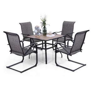 A patio furniture set with a square table and four dark-colored chairs featuring metal frames and fabric seats, arranged around the table. A vase with flowers and a decorative item sit on the table.