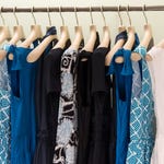 Assorted dresses in various colors and patterns on hangers.