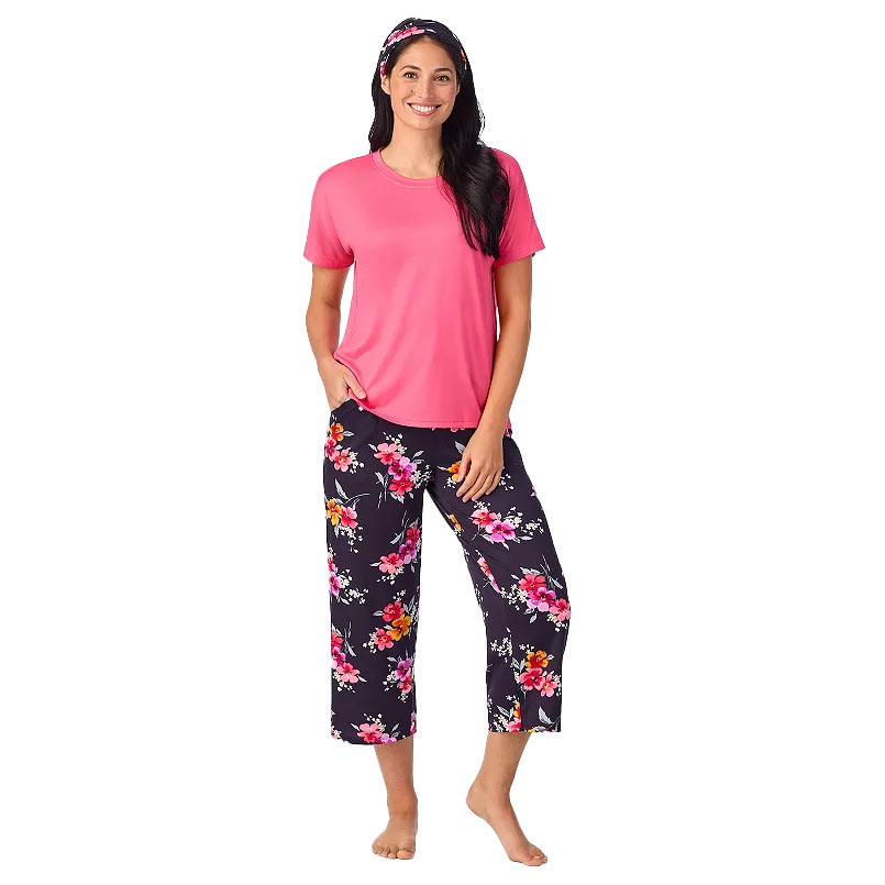 A woman is wearing a pink short-sleeve top and floral-patterned capri pants. She also has a matching floral headband.